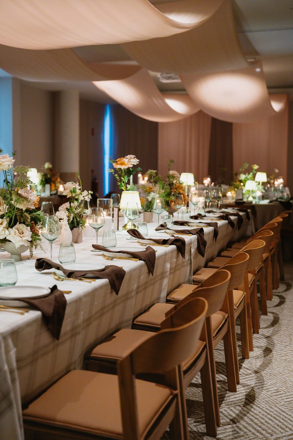 The Avani Ballroom set with long tables, draped ceiling and florals